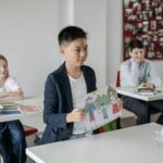 Child showcasing drawing in a classroom setting, focusing on education.